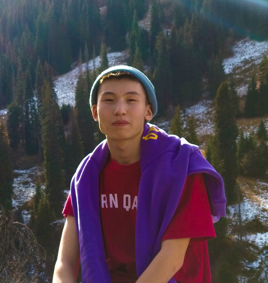 woman in purple and blue adidas shirt standing near lake during daytime